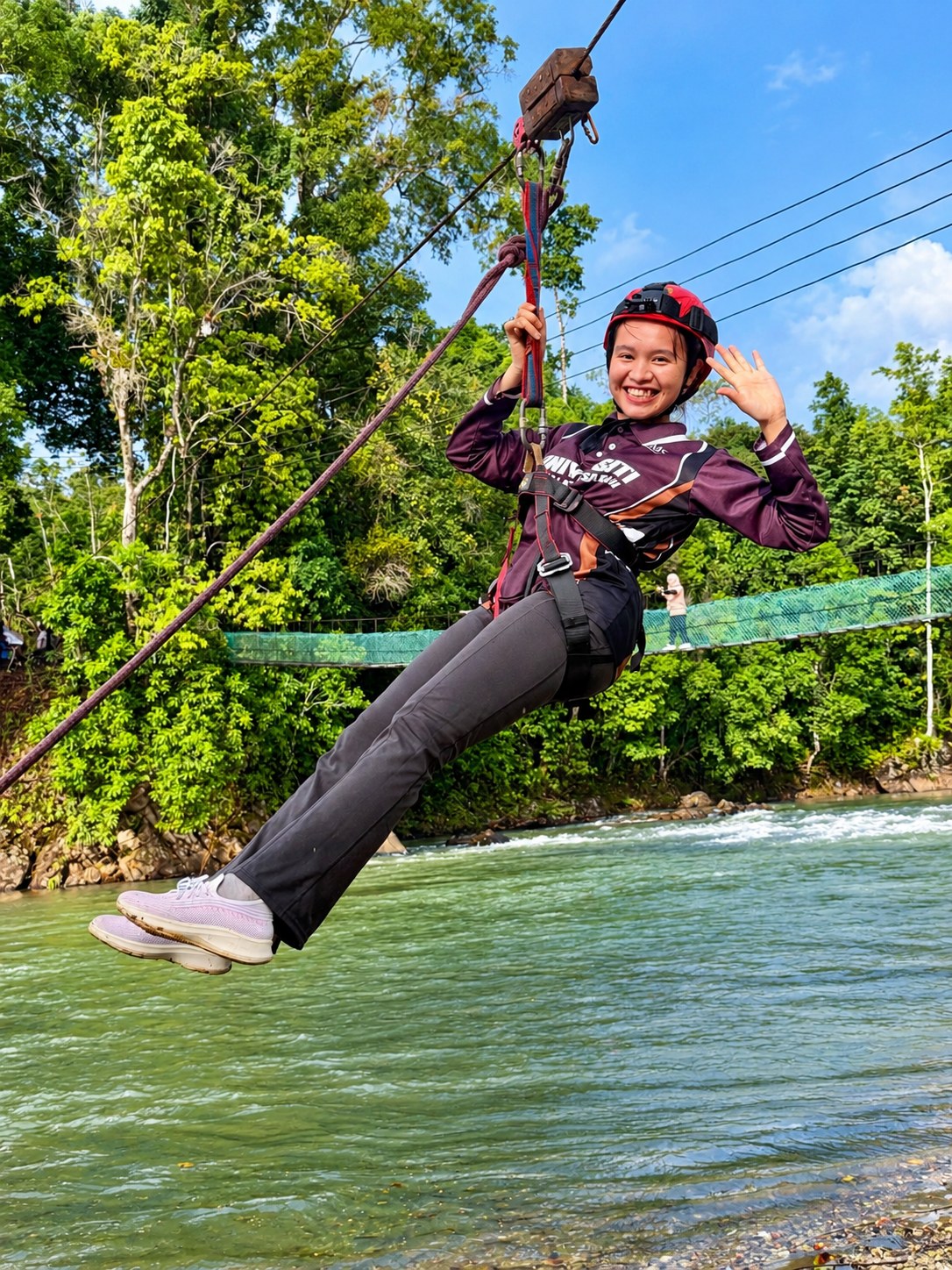 Peserta menikmati aktiviti zipline di atas sungai